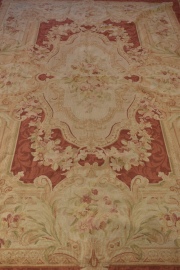 Alfombra estilo Savonerie con reservas decoración de motivos de flores y roleos. Mide: 274 x 178 cm.