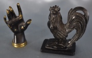 Gallo de piedra y mano de bronce. 2 Piezas. Alto: 10 cm.