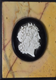 Perfil clásico, miniatura tallada, apoya sobre mármol y pizarra, cachaduras. Mide: 12,5 x 9 cm.