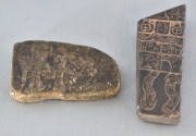 DOS FRAGMENTOS, de piedra tallada con figuras y símbolos. Largo: 6 y 4,5 cm.