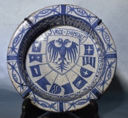 Antiguo plato hondo de cerámica española con esmalte azul y águila bicéfala. Cascaduras. Diámetro: 25,5 cm.