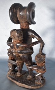 Maternidad Tschokwe, figura africana de madera tallada, con tres niños. Alto: 35 cm.
