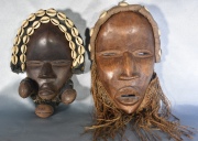 Dos máscaras africanas Dan-Guere, con caracoles aplicados. Altura: 28 cm. Ancho: 19 cm.