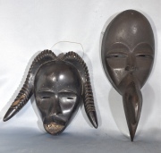 Dos máscaras africanas Dan, negras, una con cuernos y otra con pico de ave. Alto: 23 y 36 cm
