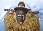 Máscara africana Bayaka de madera tallada y pintada; rodeada de rafia. Alto: 65 cm.
