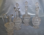 Tres Garrafas y Un Botellón de cristal tallado; una sin tapón. Total: 4 piezas. Alto máximo: 34,5 cm.