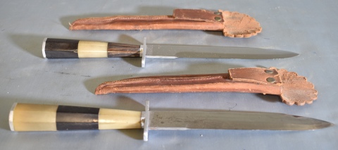 Dos cuchillos modernos, cabos de asta. Vainas de cuero. Largo: 28,3 cm.