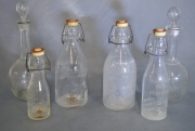 Cuatro botellas antiguas de vidrio y dos botellones. -011-