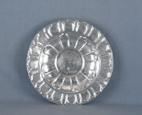 Centro hondo de plata con decoracin de ptalos y de rameados cincelados, borde con guarda sobre relieve