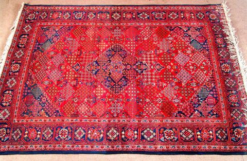 Alfombra persa fondo rojo con dec de rombos florales 140 x 200 cm.