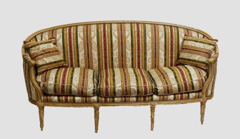 Sofa E. Luis XVI, laqueado, tapizado a bastones, con almohadones.