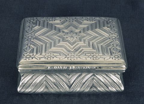 Cajita rectangular de plata cincelada.