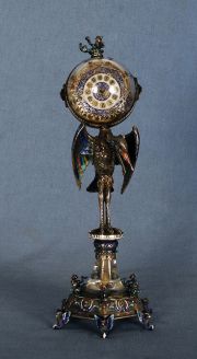 Reloj con figura de ave en el fuste, aplic. de esmalte, deterioros