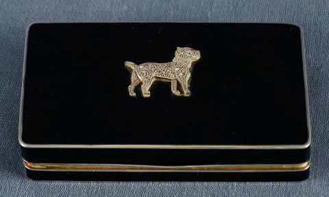 Caja de esmalte negro con figura de perro en relieve.