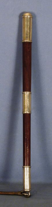Arreador de madera c/pomo, puntera y pasador de plata con bordes con guarda de cintas entrelazadas. 51,5 cm.