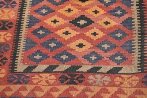 Carpeta Kilim de lana con motivos geométricos. 3 franjas en la guarda, azul, rojo y naranja. Mide 285 x 195. Desgastes