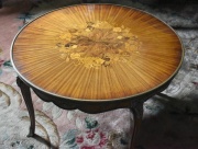 Mesa ratona circular, marquetería floral y aplicaciones de bronce, falta un regatón. Diámetro 78,5 cm Alto 47 cm.