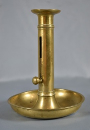Candelero de bronce con vela regulable. 18,5 cm.