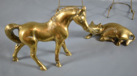 Buey recostado y caballo, dos figuras de bronce dorado.