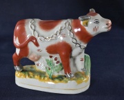 Vaca lechera de porcelana policromada, con ménsula. (212)