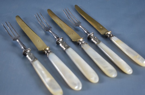 16 cubiertos para lunch: 8 cuchillos y 8 tenedores de distintos diseños, mangos de nácar, deterioros. (803)