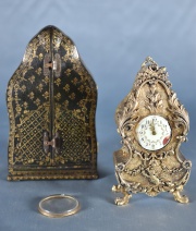 Reloj estilo Luis XV de bronce con putino. Esfera con esmalte saltado. Estuche de cuero. (139)