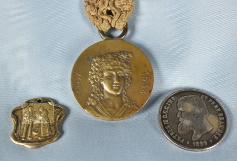 Moneda portuguesa y tres medallas.