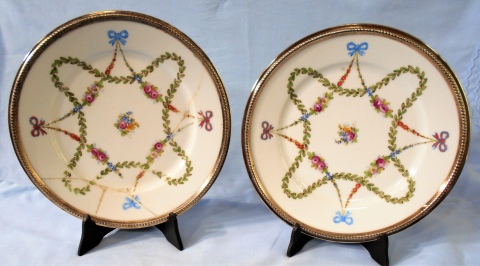 Par de platos de porcelana Saxe, con virola de plata, decorado con flores y punzones ilegibles, uno restaurado. Diámetro