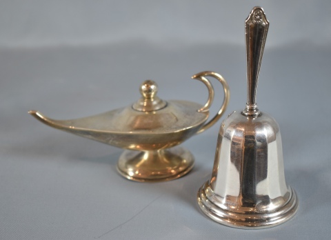 Do piezas: Lámpara de aceite mejicana y campana en metal plateado.
