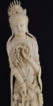 Mujer con canastilla, talla de marfil, con base de madera calada. Faltantes. Aprox. 60 cm.
