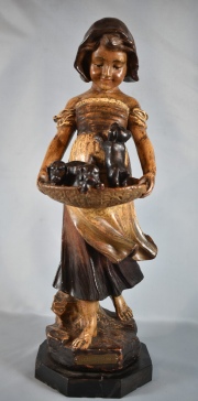 Niña con sombrero, sosteniendo una canasta con perros, escultura en cerámica. Base de mármol, restaurado.