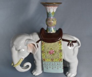 Elefante cargando vaso, de porcelana china. Alto: 25 cm.