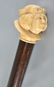 Baston, de caña, pomo con figura de joven, tallado en marfil. 95 cm.