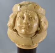 Baston, de caña, pomo con figura de joven, tallado en marfil. 95 cm.