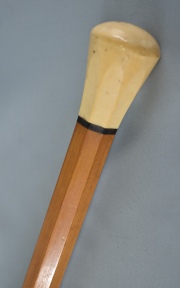 Baston, de madera clara facetada. pequeño pomo de marfil. Puntera de asta con desperfectos. 90 cm.