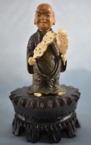 Pequeña figura de chino en bronce con palmetas en la mano. 18 cm.