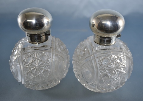 Par de frascos perfumeros de cristal, tapas plata inglesa. Una tapa de vidrio faltante, Alto 14 cm.