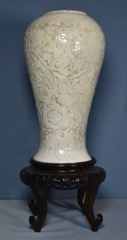 Vaso chino de cerámica blanca con base de madera. Base con orificio de origen y cachaduras. Alto con base: 50,5 cm.