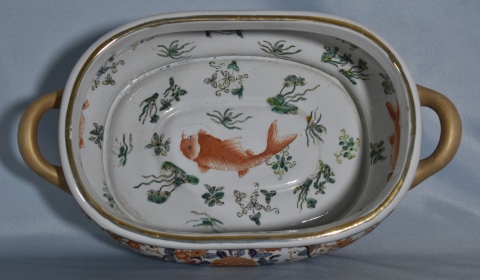 Centro chino, de porcelana oval con dos asas y decoración de peces. Frente: 45 cm.
