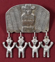 PARTICULAR PRENDEDOR ARAUCANO, gruesa placa donde se destaca figura de rehue. Cuatro colgantes con formas de hombrecillo