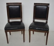 Dos sillas tapizadas en cuero negro.