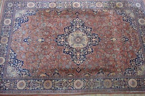 Alfombra persa, campo brick, decoración floral, medallon central. Mide: 311 x 202 cm.