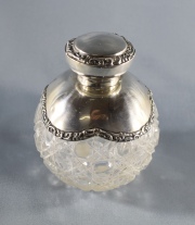 PERFUMERO, de cristal tallado con decoraciones geométricas, y montura y tapa de plata inglesa. Alto: 9, 2 cm.