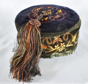 FEZ, sombrero turco de fieltro negro, con bordados en amarillo y naranja, decoración de flores y hojas.