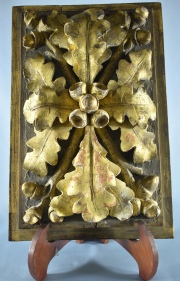 PLACA ORNAMENTAL, de madera tallada y dorada en alto relieve. Con ornato de hojas y frutos. Mide: 33,5 x 22 cm.
