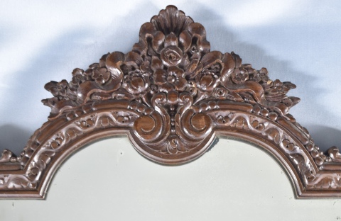ESPEJO DE PARED, con marco de madera tallada. Cresta irregular con decoración vegetal. Mide: 80 x 75 cm.