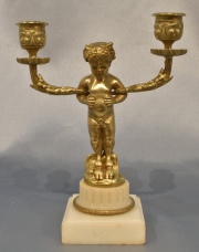CANDELABRO DE BRONCE, en forma de Fauno, quien sostiene dos brazos. Base de mármol. Alto total: 19 cm.