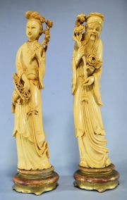 DAMA CON CANASTA Y HOMBRE CON RAMEADO, dos figuras de marfil tallado sobre bases de madera dorada. Alto total:35,5 cm.