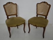 PAR DE SILLAS ESTILO LUIS XV, de nogal tallado, respaldos esterillados, averías, asiento tapizado en tela beige.