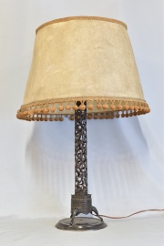 LAMPARA ORIENTAL, en forma de columna sostenida por tres trompas de elefante. Con pantalla de pergamino. Averías. 72 cm.